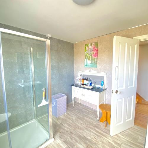 a bathroom with a shower and a sink and a desk at Luxury holiday rental with sea views on the Wild Atlantic Way in Tralee