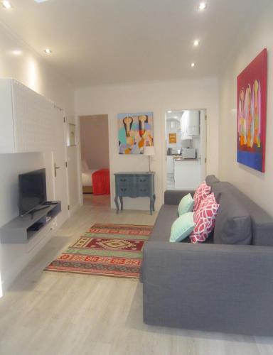 a living room with a couch and a television at Alfama Shabby Chic Flat in Lisbon
