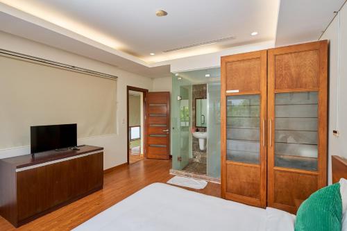a bedroom with a bed and a flat screen tv at Ocean Sunny Villas Da Nang in Danang