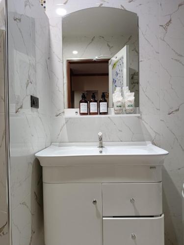 a white bathroom with a sink and a mirror at Baan Plaifah Khao Yai Hotel in Khao Yai