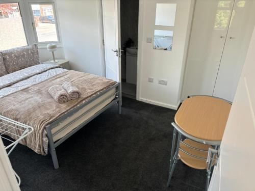 a bedroom with a bed and a table and a chair at Cosy rooms in Cambridge in Cambridge