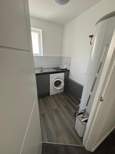 a small bathroom with a washing machine and a sink at Cosy rooms in Cambridge in Cambridge