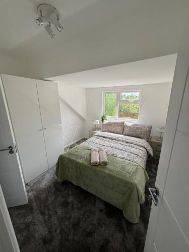 a bedroom with a bed with two pink slippers on it at Cosy rooms in Cambridge in Cambridge
