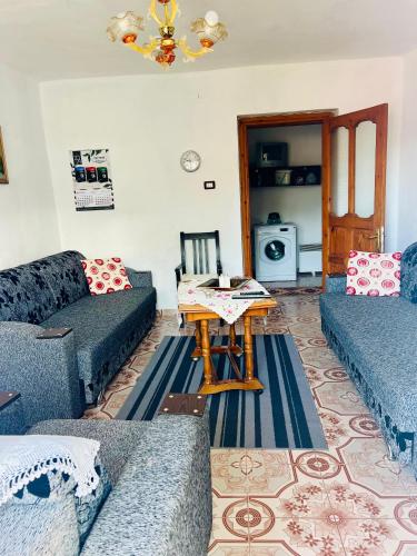 una sala de estar con sofás azules y una mesa. en Guest House Leskovik, en Leskovik