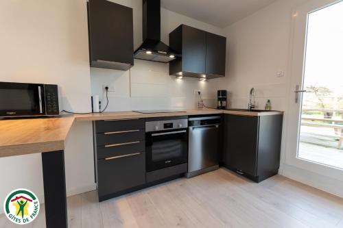 a kitchen with black appliances and a wooden counter top at Orgîte in Juvigny-sur-Marne