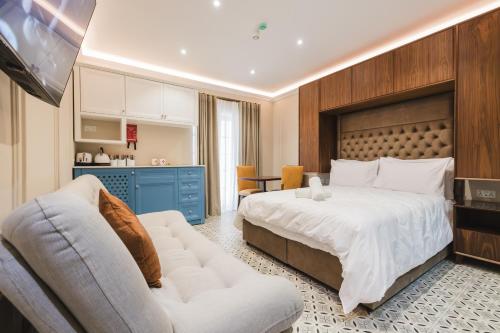 a bedroom with a large bed and a couch at IŻ-ŻEBBUĠA BOUTIQUE SUITES in Żebbuġ
