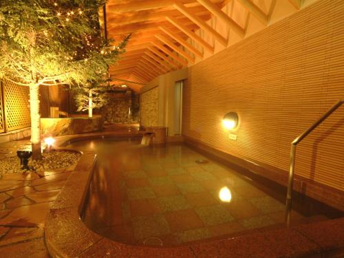 een zwembad in een gebouw met een muur bij APA Hotel & Resort Sapporo in Sapporo