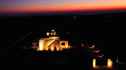 a building lit up at night with lights at Leukos, dimora di charme in Salve