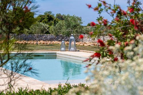 a swimming pool in a yard with two silver objects at Leukos, dimora di charme in Salve