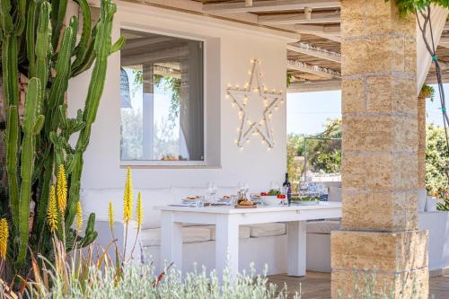 a patio with a white table and a cactus at Leukos, dimora di charme in Salve