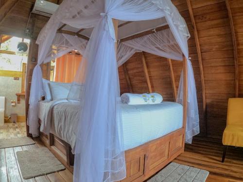 a bedroom with a bed with a canopy at Sundown Lake Hotel & Spa in Habarana