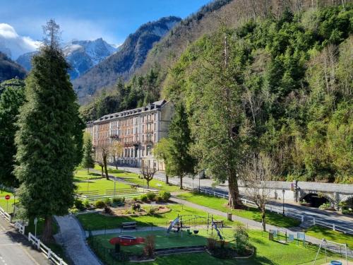 a park in front of a building in the mountains at Cocon Montagnard in Eaux-Bonnes