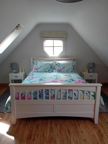 Cama blanca en habitación con ventana en Luxury holiday rental with sea views on the Wild Atlantic Way, en Tralee