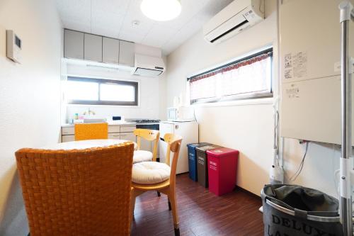 uma cozinha com mesa e cadeiras num quarto em Sakurajima Parkside House B em Osaka