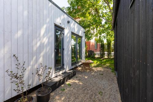 a small white house with a bench next to it at Baltic Beach Houses & Jomas in Jūrmala