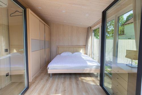 a bedroom with a bed and a large window at Baltic Beach Houses & Jomas in Jūrmala