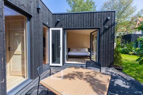 a black tiny house with a bedroom and a table at Baltic Beach Houses & Jomas in Jūrmala