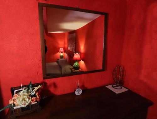 a red room with a mirror on a red wall at La Tana degli Ernici in Vico nel Lazio