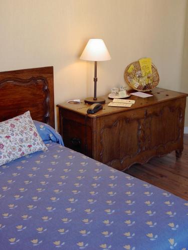 a bedroom with a bed and a desk with a lamp at Hôtel Du Théâtre Centre Historique - Parking Souterrain Public Gratuit in Metz