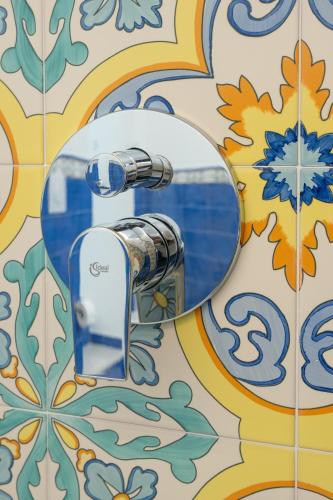 a mirror on a tile bathroom with a toaster at Aria - Suite in Capri in Capri