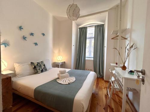 a bedroom with a bed and a desk and birds on the wall at 262 Baixa Guesthouse in Lisbon