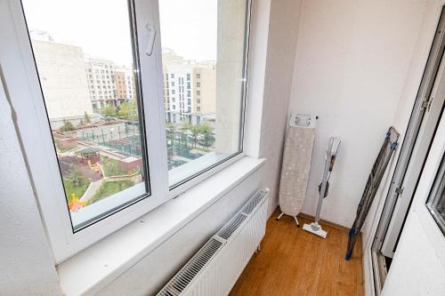 an empty room with a window and a radiator at Красивые апартаменты на Экспо in Taldykolʼ