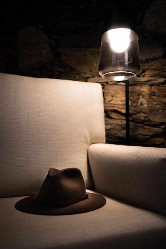 a hat sitting on a couch next to a lamp at Quinta da Pousada Casa de Campo in Santa Marta de Penaguião