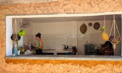 une femme debout dans une cuisine avec des bananes au comptoir dans l'établissement Binta Boutique Hotel, à Nungwi