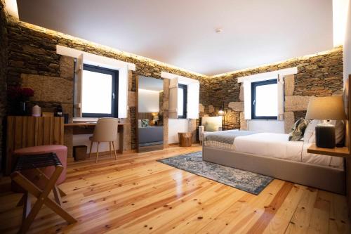 a bedroom with a bed and a brick wall at Quinta da Pousada Casa de Campo in Santa Marta de Penaguião
