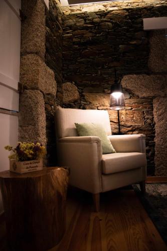a living room with a chair and a lamp at Quinta da Pousada Casa de Campo in Santa Marta de Penaguião