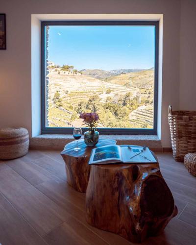 a room with a tree stump coffee table with a large window at Quinta da Pousada Casa de Campo in Santa Marta de Penaguião