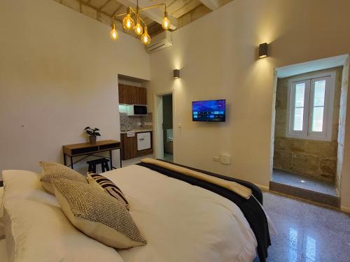 a bedroom with a large bed with a tv on the wall at Sbejha Guest House in Naxxar