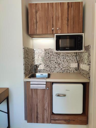 a small kitchen with a sink and a microwave at Sbejha Guest House in Naxxar