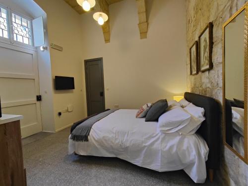 a bedroom with a bed with white sheets and pillows at Sbejha Guest House in Naxxar
