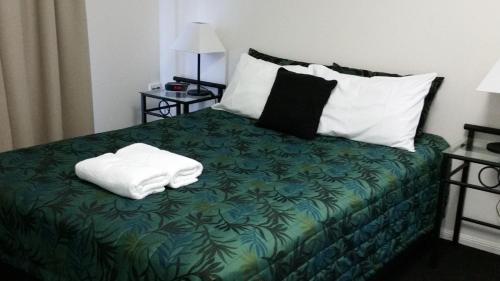 A bed or beds in a room at Port Denison Motor Inn