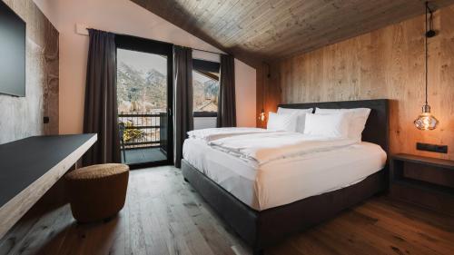 ein Schlafzimmer mit einem großen Bett und einem großen Fenster in der Unterkunft Triple A Chalets in Seefeld in Tirol