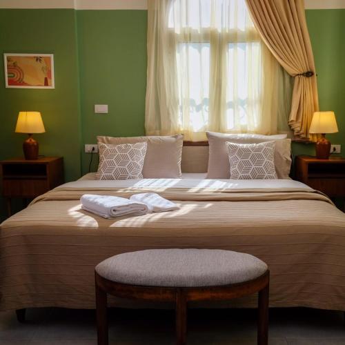 a bedroom with a large bed with two towels on it at VICTORIA BOUTIQUE HOTEL in El Mîna