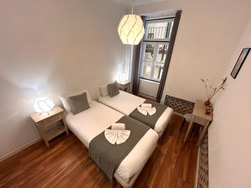 a small bedroom with a bed with bows on it at 262 Baixa Guesthouse in Lisbon