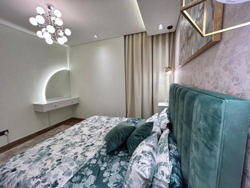 Schlafzimmer mit einem Bett mit grünem Kopfteil in der Unterkunft Luxury Romantic Sea View Apartment. in Manama