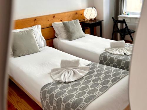 two beds in a hotel room with towels on them at 262 Baixa Guesthouse in Lisbon