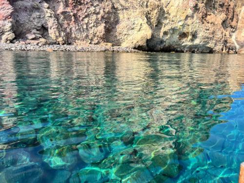 a body of water next to a rocky cliff at Hotel Boutique Ideal in Ischia