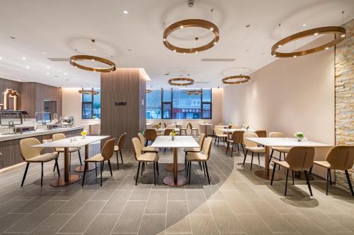 a restaurant with tables and chairs and a counter at 朗丽兹酒店深圳罗湖口岸店 in Shenzhen