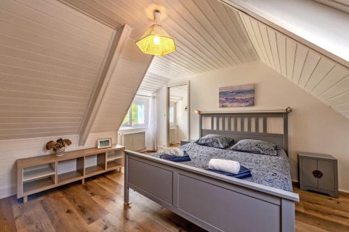 une chambre avec un grand lit dans un grenier dans l'établissement Ty Colo Plougasnou - Longère à 2.5km de la plage, à Plougasnou