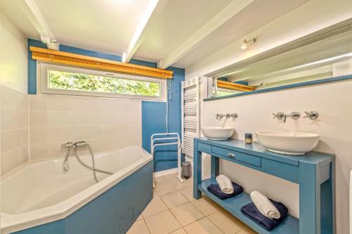 une salle de bain avec deux lavabos et une baignoire et une baignoire dans l'établissement Ty Colo Plougasnou - Longère à 2.5km de la plage, à Plougasnou