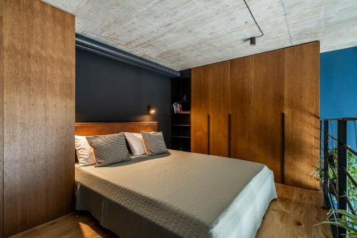 Un dormitorio con una cama y una pared de madera. en Paupys lofts, en Vilna