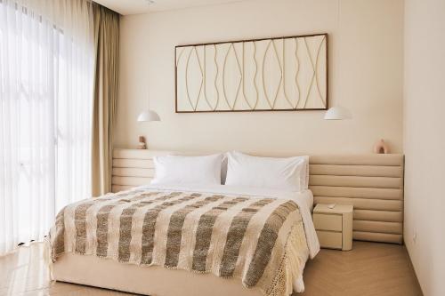 a bedroom with a bed with a picture on the wall at Casa Lily - Luxury 3 Bedroom Villa in Bingin in Uluwatu