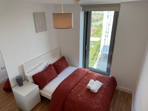a bedroom with a bed with red pillows and a window at Your private oasis in Manchester in Manchester