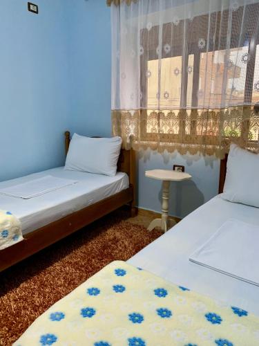 a room with two beds and a table in it at Guest House Dimos Kristi in Përmet