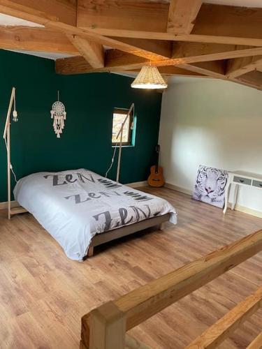 a bedroom with a bed and a green wall at Grande maison type Périgourdine in Montignac