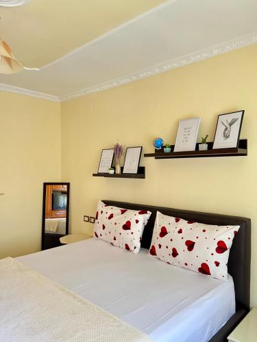 a bedroom with a bed with red and white pillows at Guest House Dimos Kristi in Përmet